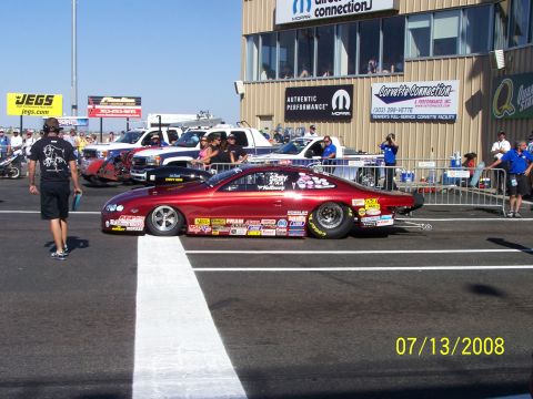 1972 Ford Ranchero - A red drag racing car sits on the track at Bandimere Speedway on a sunny day.