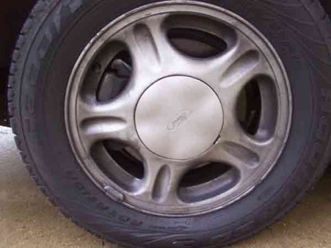 1998 Ford Taurus - Close-up of a vehicle's wheel, a hubcap with a Ford logo.