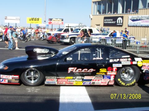 1972 Ford Ranchero - A black drag car with extensive sponsor decals and a prominent hood scoop sits on the track.