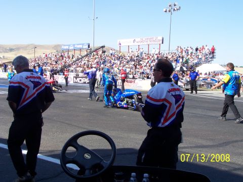 1972 Ford Ranchero - A drag racing event is underway with crew members and spectators present on a sunny day.