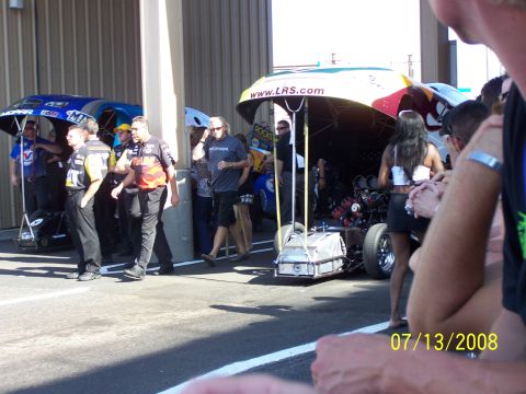 1972 Ford Ranchero - A drag racing car is being worked on by a crew, with spectators watching nearby.