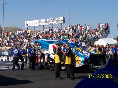 1972 Ford Ranchero - A drag racing car is prepared on the track with a crowd watching in the background.