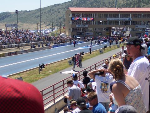 1972 Ford Ranchero - A crowd watches a drag race event with a grandstand and track visible under a sunny sky.