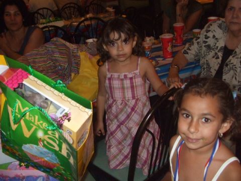 2008 Jeep Cherokee - Children are gathered at a party, with a 'Make a Wish' gift bag prominently displayed.
