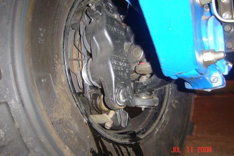 1978 Ford Bronco - A close-up view of a vehicle's brake system, showing the caliper, rotor, and suspension components.