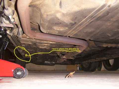 1998 Ford Taurus - The underside of a vehicle is shown, with a focus on the exhaust system and a red jack.