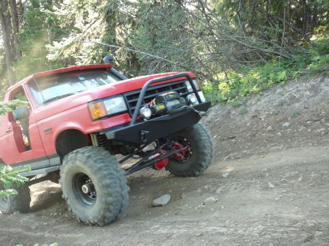 1991 Ford Bronco - This modified 1991 Ford Bronco navigates a steep, rocky incline on a wooded trail.