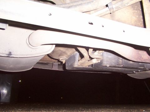 1998 Ford Taurus - The undercarriage of a vehicle shows the exhaust system components, including the muffler and pipes.