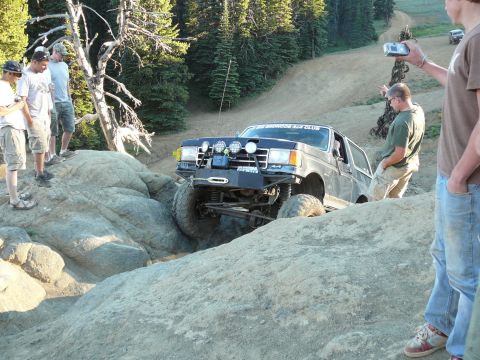 1991 Ford Bronco - A 1991 Ford Bronco navigates a challenging rocky terrain during an off-road event, with spectators observing the scene.