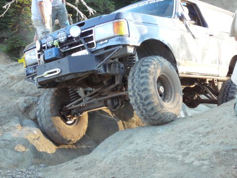 1991 Ford Bronco - This modified Ford Bronco navigates a rocky trail with its front-right wheel high in the air.