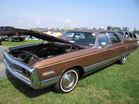 2001 Ford Crown Victoria - A brown Chrysler New Yorker is parked on a grassy field with its hood open, showing the engine bay.