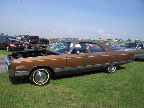 2001 Ford Crown Victoria - A brown sedan is parked on grass with its hood open, under a clear blue sky.
