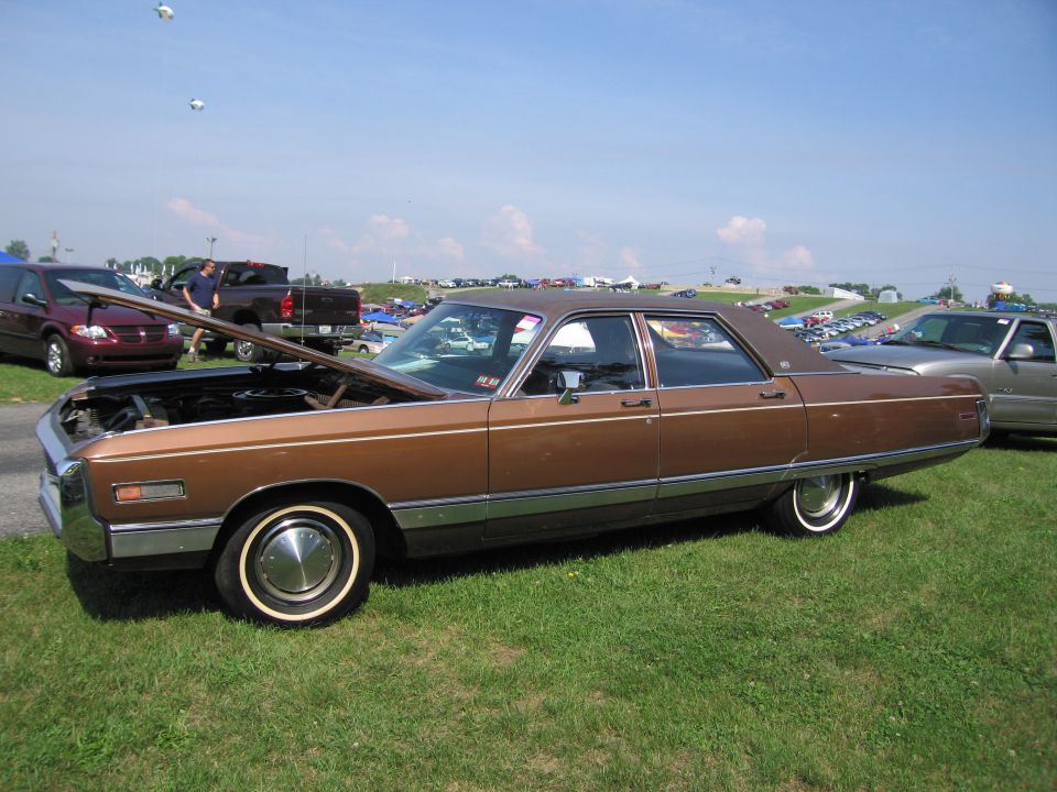 Brown sedan with hood open, chrome trim, and whitewall tires