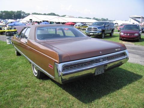 2001 Ford Crown Victoria - Rear view of a brown 1970s Chrysler sedan parked on grass at an outdoor event.