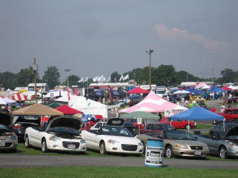 2001 Ford Crown Victoria - A variety of vehicles are displayed under tents at an outdoor gathering.