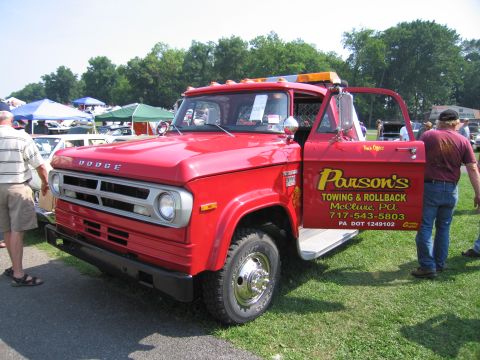 2001 Ford Crown Victoria - A red Dodge tow truck is parked on grass with its driver's door open, displaying company information.