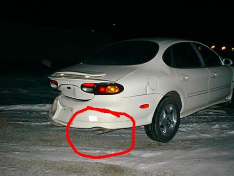 1998 Ford Taurus - The rear bumper of a white sedan is highlighted in red, showing damage or a specific feature.