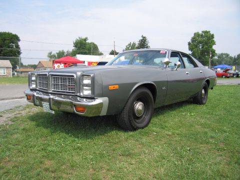 2001 Ford Crown Victoria - This 1977 Dodge Monaco sedan is shown from the front 3/4 view, parked on a grassy field.