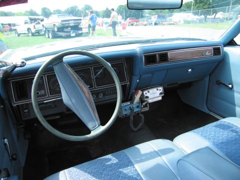 2001 Ford Crown Victoria - Interior view of a light blue car, a classic dashboard, steering wheel, and a mounted CB radio.
