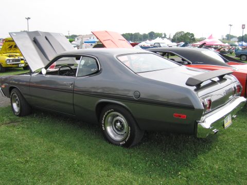 2001 Ford Crown Victoria - A gray 1975 Dodge Dart Sport is displayed with its hood open at an outdoor car show.