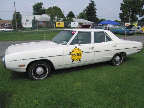 2001 Ford Crown Victoria - A white sedan with an Alaska State Police emblem on the side sits on a grassy field.