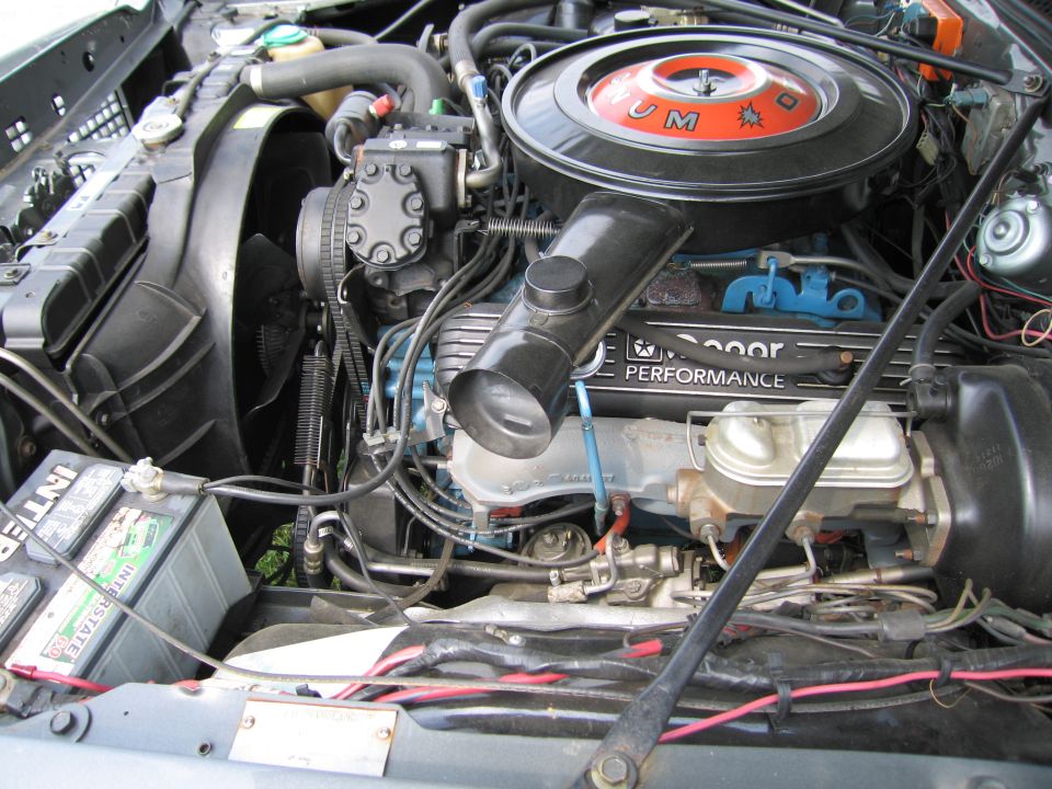 Engine bay with a black air cleaner and 'DODGE PERFORMANCE' written on the valve cover