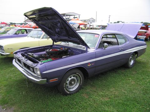 2001 Ford Crown Victoria - A purple Dodge Dart is displayed with its hood and trunk open at an outdoor car show.