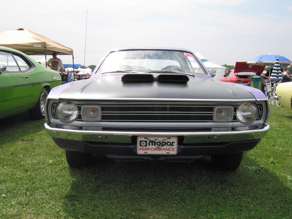 Front view of a purple and black Dodge Dart with hood scoops and a Mopar Performance license plate frame