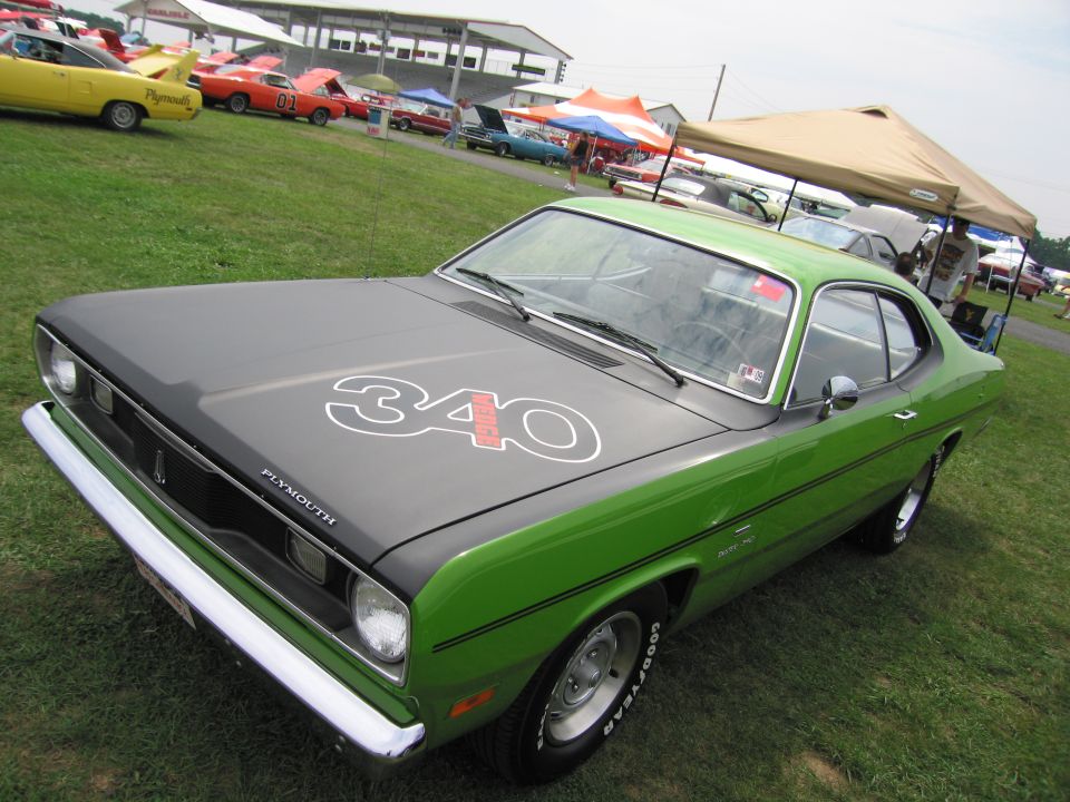 Green Plymouth Duster with black hood and '340' decal, parked on grass