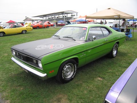 2001 Ford Crown Victoria - A green 1970 Plymouth Duster 340 is parked on grass at an outdoor car show.