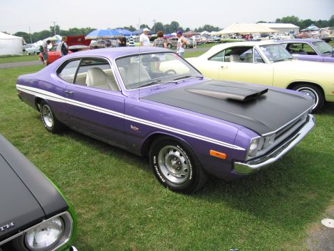 2001 Ford Crown Victoria - A purple 1970s muscle car is parked on grass at an outdoor car show.