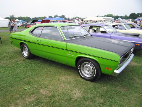 2001 Ford Crown Victoria - A bright green muscle car with a black hood and racing stripes is parked on grass at an outdoor event.