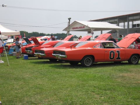 2001 Ford Crown Victoria - Multiple Dodge Charger General Lee replicas displayed with hoods open at an outdoor event.