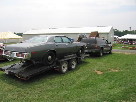 2001 Ford Crown Victoria - Photo of a sedan on a flatbed trailer towed by an SUV at the Carlisle show grounds.