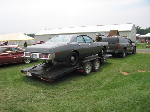 2001 Ford Crown Victoria - Photo of a four-door sedan loaded on a flatbed trailer at an outdoor car show.