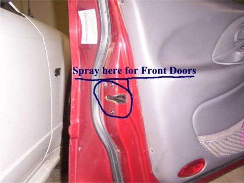 1998 Ford Taurus - Close-up of a door latch mechanism with handwritten instructions indicating where to spray for front doors.