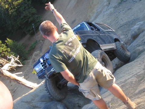 1989 Ford Bronco - A person is actively climbing on large rock formations in an outdoor setting.