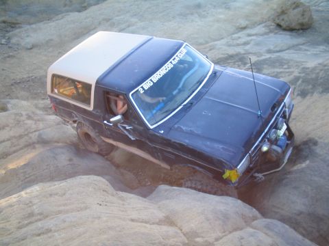 1989 Ford Bronco - Ford Bronco tackling a challenging off-road course, demonstrating its 4x4 capabilities on rough terrain.