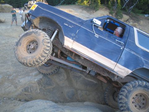 1989 Ford Bronco - A blue 1989 Ford Bronco navigates a rocky trail during an off-road event.