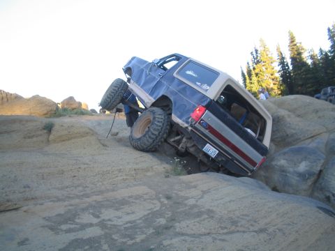 1989 Ford Bronco - A modified Ford Bronco navigates a rocky incline, its off-road capabilities.