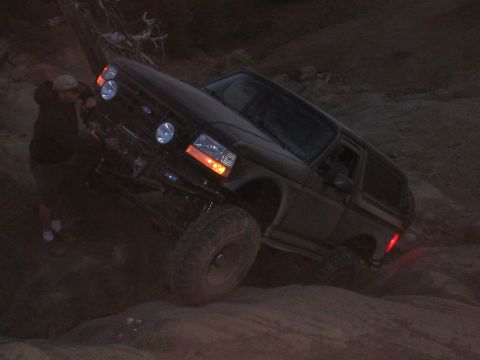 1989 Ford Bronco - Ford Bronco navigating difficult off-road terrain at dusk.