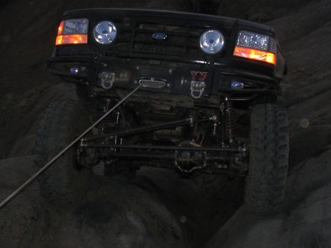 1989 Ford Bronco - This modified Ford Bronco navigates rocky terrain with its front wheels elevated.