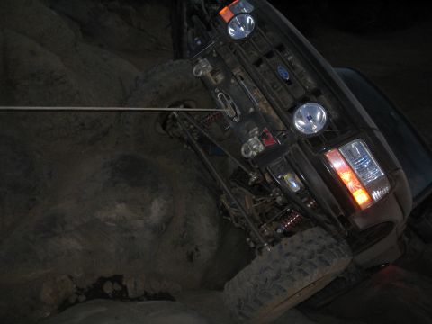 1989 Ford Bronco - A 1989 Ford Bronco is shown navigating a rocky terrain, with a tow rope attached.