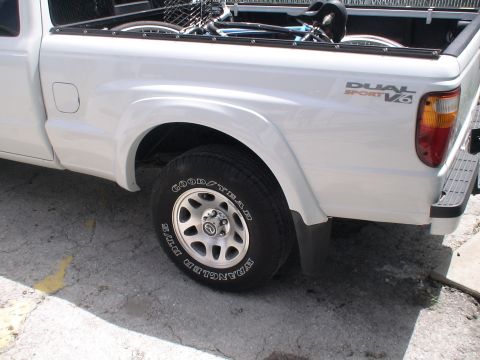 1993 Ford C-350 (Centurion Conversions) - Rear view of a white pickup truck showing the wheel and bed area.