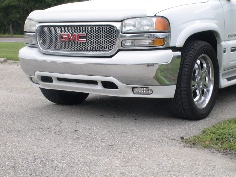 1993 Ford C-350 (Centurion Conversions) - Front view of a white GMC Denali SUV, its distinctive grille and chrome bumper.