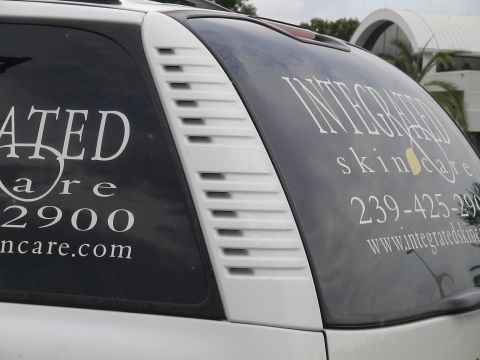 1993 Ford C-350 (Centurion Conversions) - Vehicle rear window displays business advertising for Integrated Skincare.