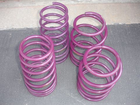 1993 Ford Taurus - Four purple coil springs are arranged on a gray surface.