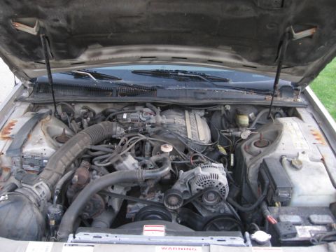 1995 Ford Thunderbird - The engine bay of a 1995 Ford Thunderbird is visible with the hood open.