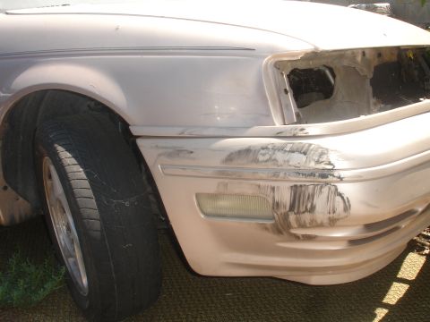 1991 Ford Taurus - A silver car with extensive damage to its front end is shown from the front-left side.