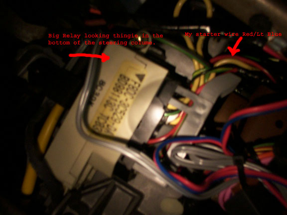 Close-up of automotive wiring and a relay module, with red and blue wires visible